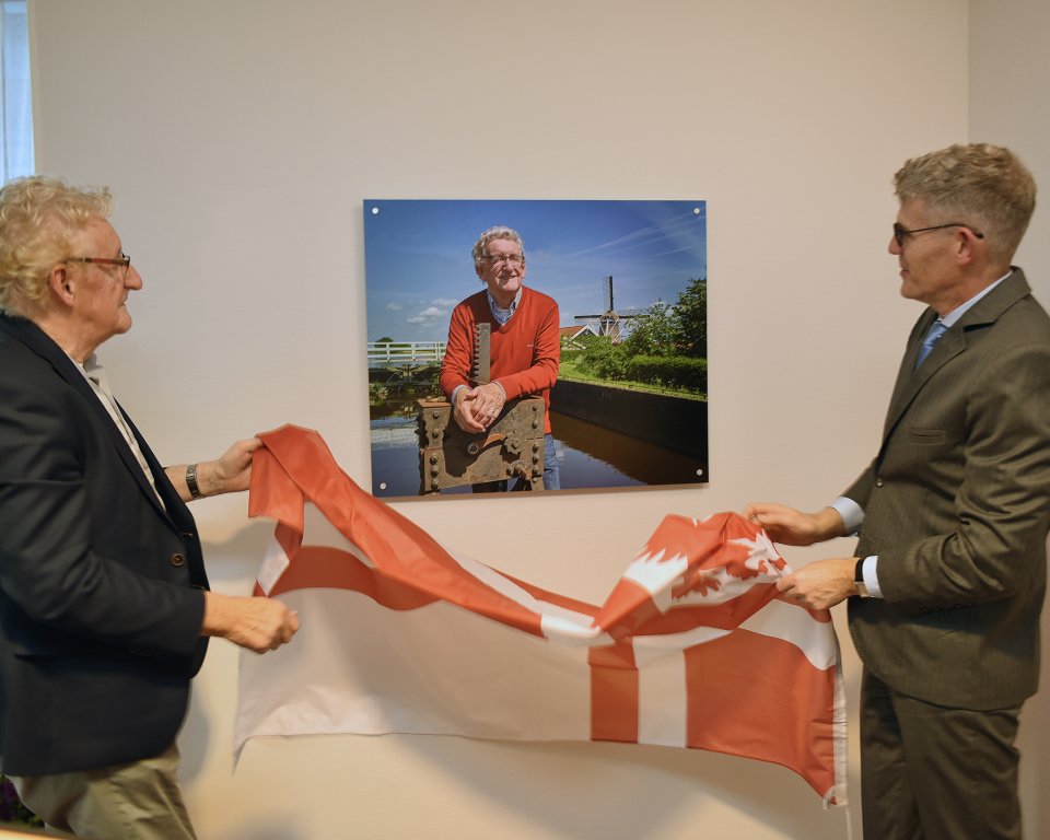 Ereburger Johan Veenstra onthult samen met burgemeester André van de Nadort zijn portret in de galerij ereburgers van gemeente Weststellingwerf. 