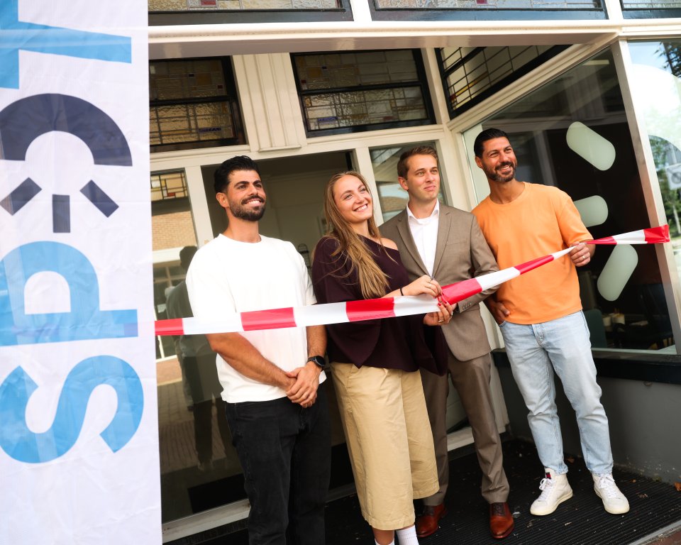 Medewerkers van SPOT knippen het lintje door tijdens de opening van de nieuwe locatie.