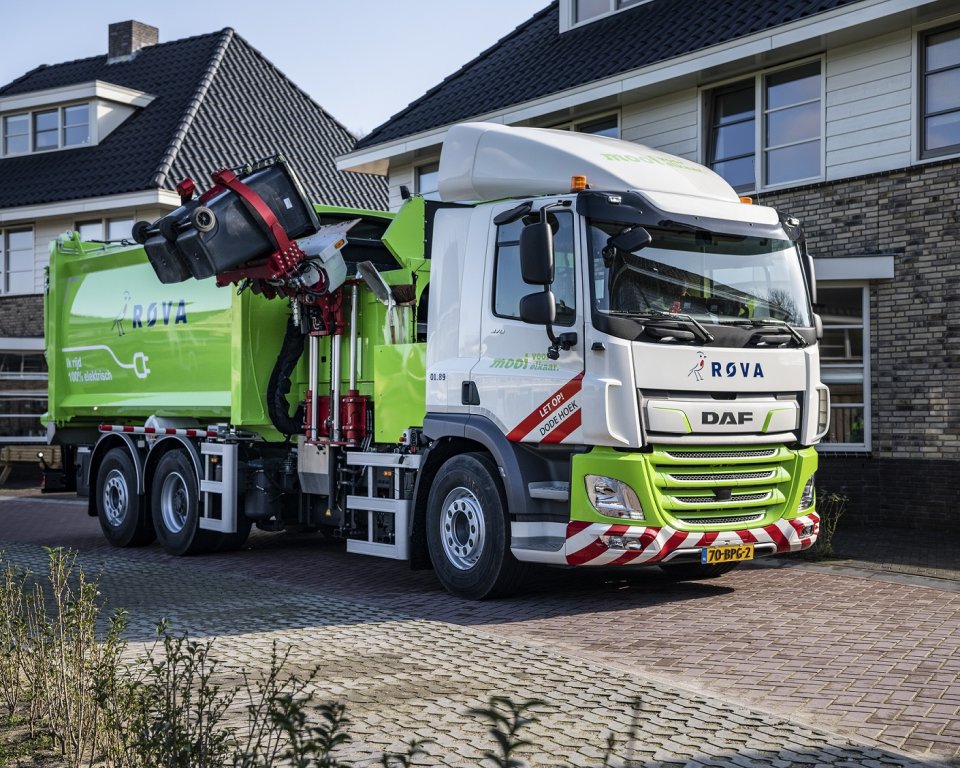 Een vuilniswagen leegt een afvalbak