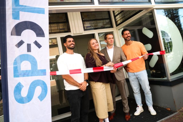Medewerkers van SPOT knippen het lintje door tijdens de opening van de nieuwe locatie.