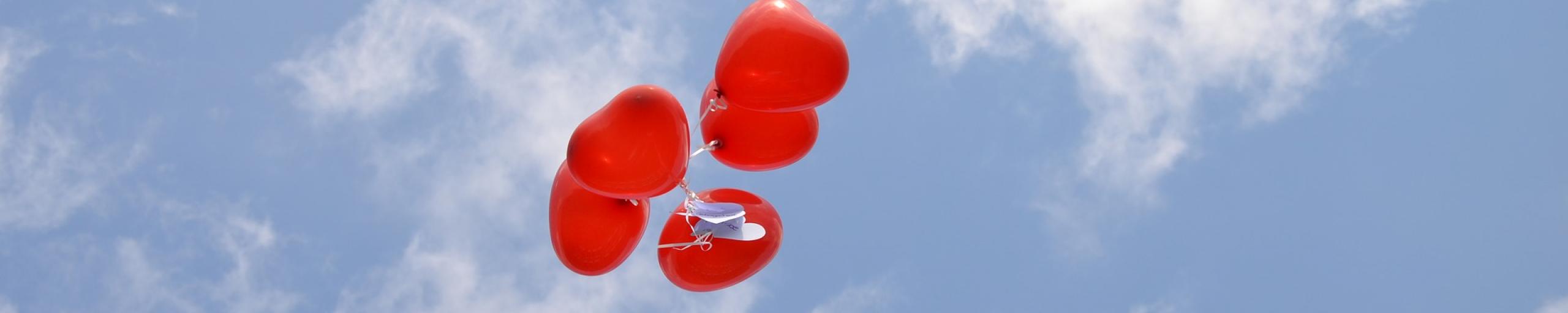 Rode hartjes ballonnen in een zonnige lucht