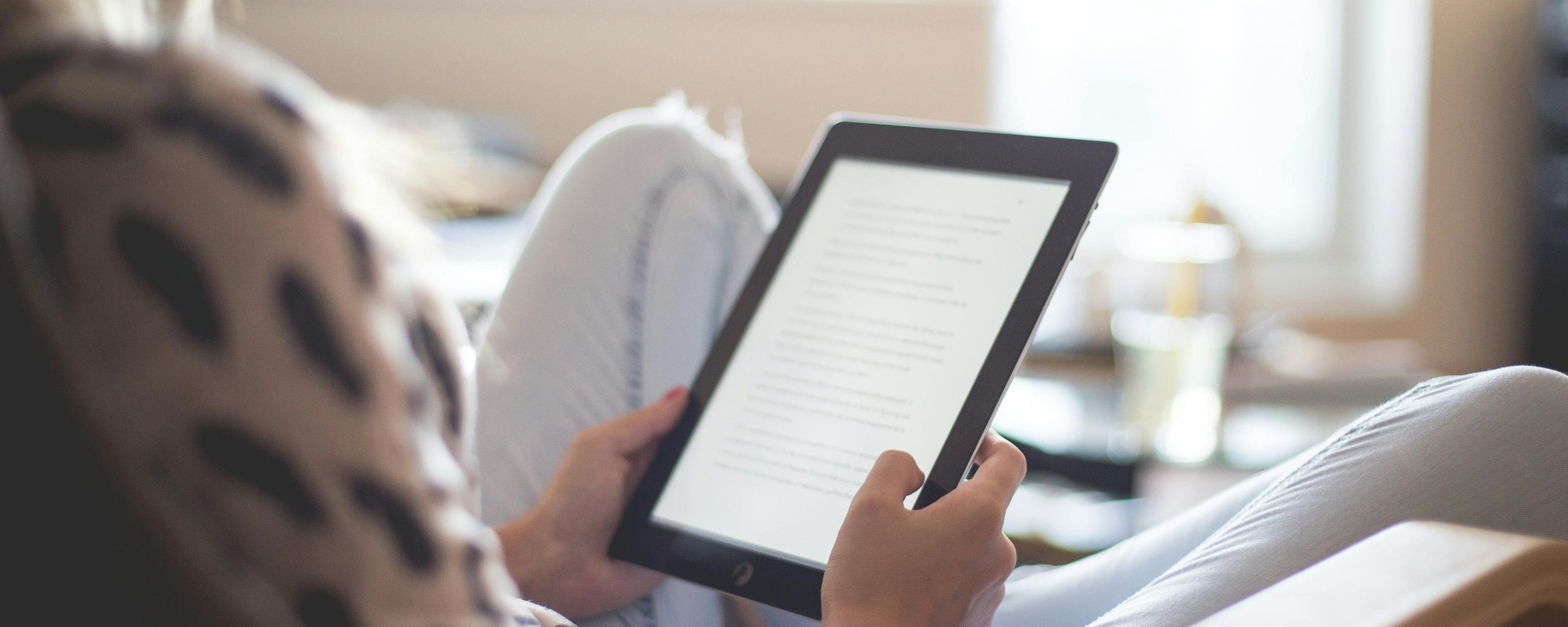 Mevrouw lezend op een e-reader