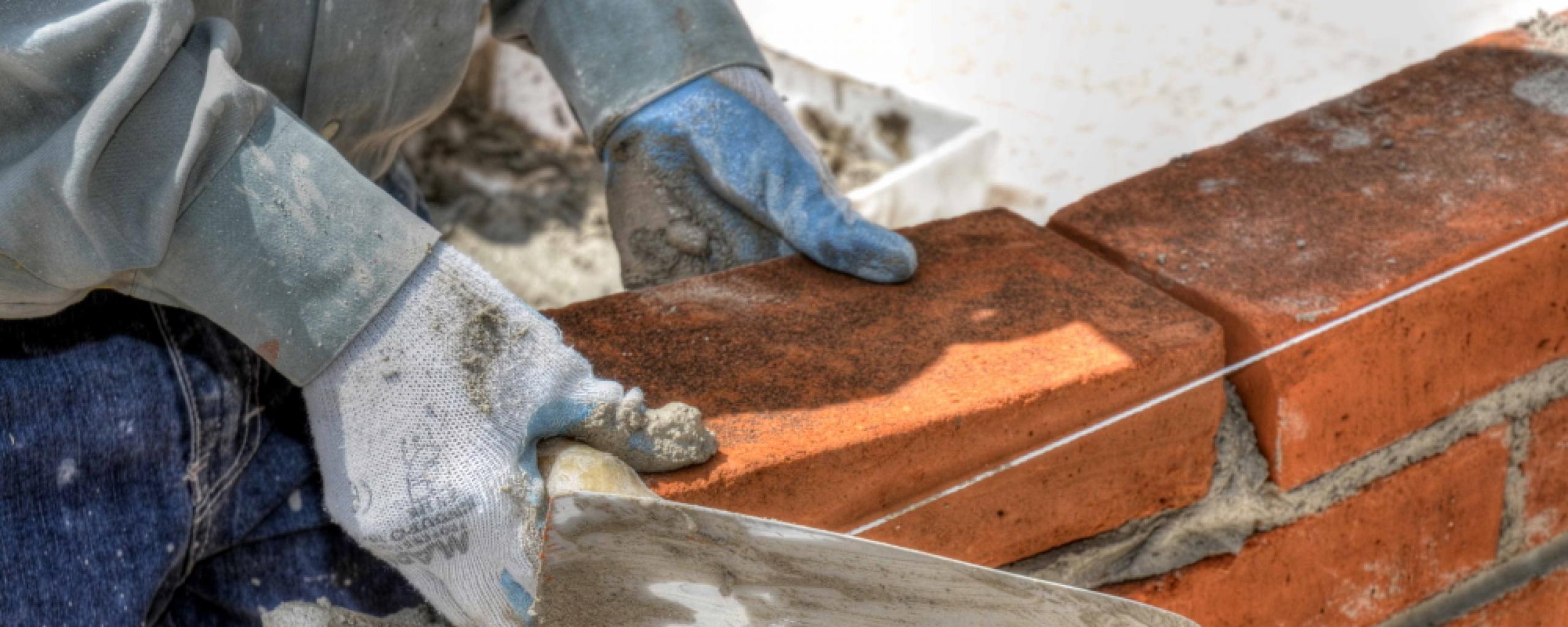 Metselaar aan het werk met troffel en stenen