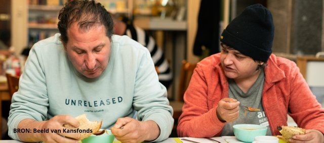 Twee mannen eten soep met brood
