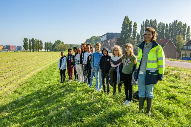 Kinderen op de dijk tijdens een gastles over dijken