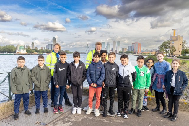 De leerlingen met Fanny en Sjoerd poseren bij Dokhaven langs de Nieuwe Maas