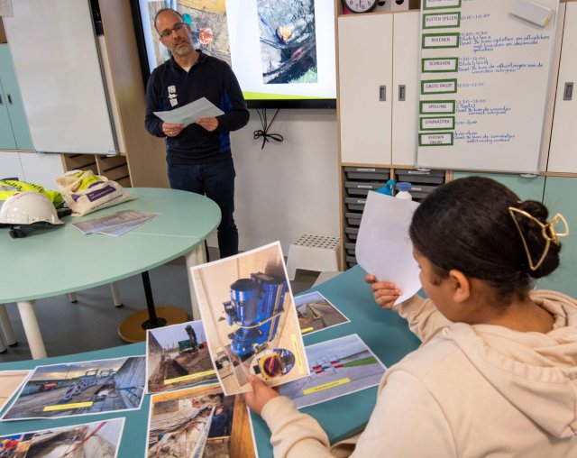 De leerlingen bekijken met foto’s wat er allemaal moet gebeuren om een kapotte leiding te repareren. 