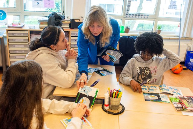 Heemraad Hennie Wiersma deelt Droppie Water boekjes uit in de klas