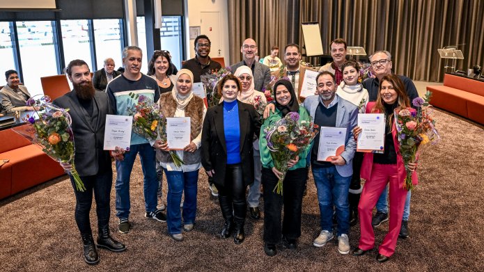 Groep statushouders met hun certificaat en medewerkers van IJsselgemeenten