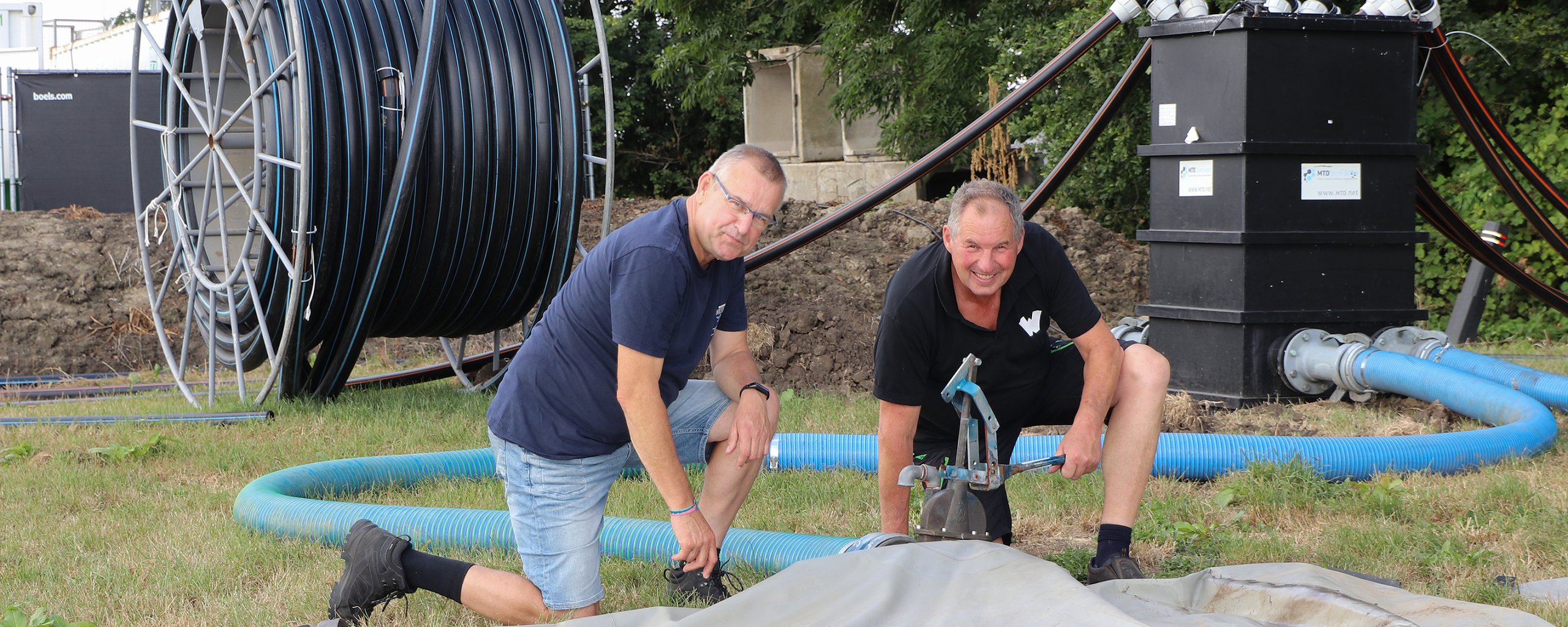 Onze collega Sietze Koster (rechts) en Henk Visser van Walibi bij de enorme zakken vol drinkwater