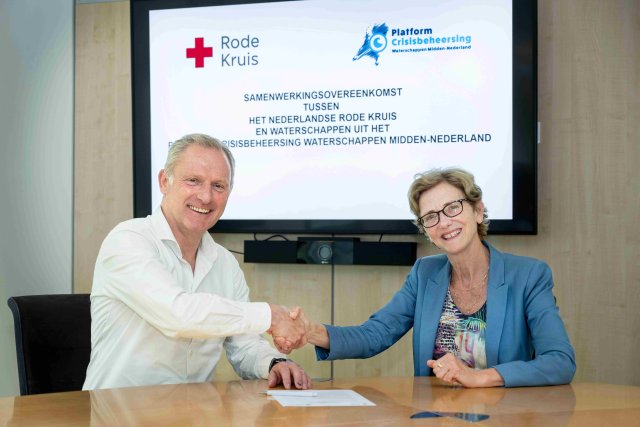 Secretaris-directeur Cis Apeldoorn van De Stichtse Rijnlanden en Rode Kruisdirecteur Harm Goossens ondertekenen de samenwerkingsovereenkomst.