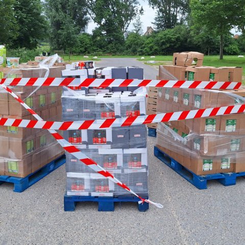 Pallets met kartonnen dozen gevuld met yoghurt. Om de pallets is rood/wit afzet lint gewikkeld
