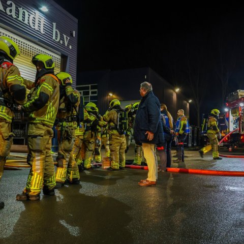 Brandweermensen in de nacht met daartussen burgemeester Han Weber