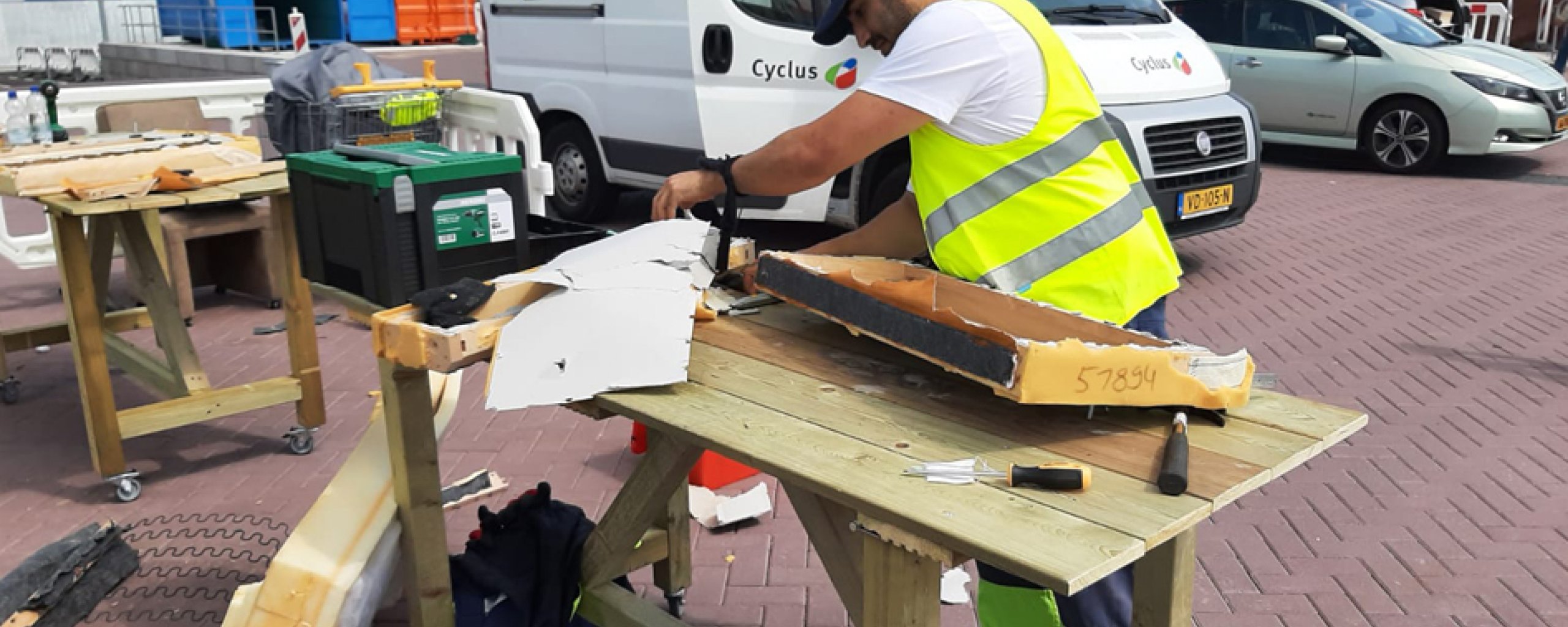 Medewerker van Cyclus demonteert meubels