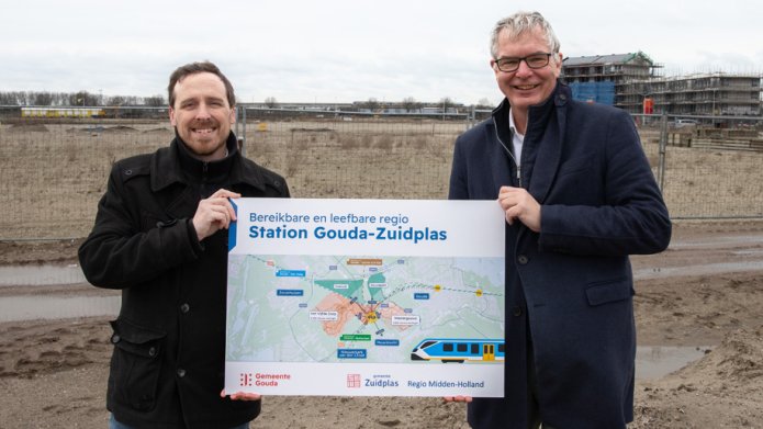 Wethouder Daan de Haas van Zuidplas en wethouder Michel Klijmij - Van der Laan van Gouda met informatiebord voor nieuw treinstation Gouda-Zuidplas.