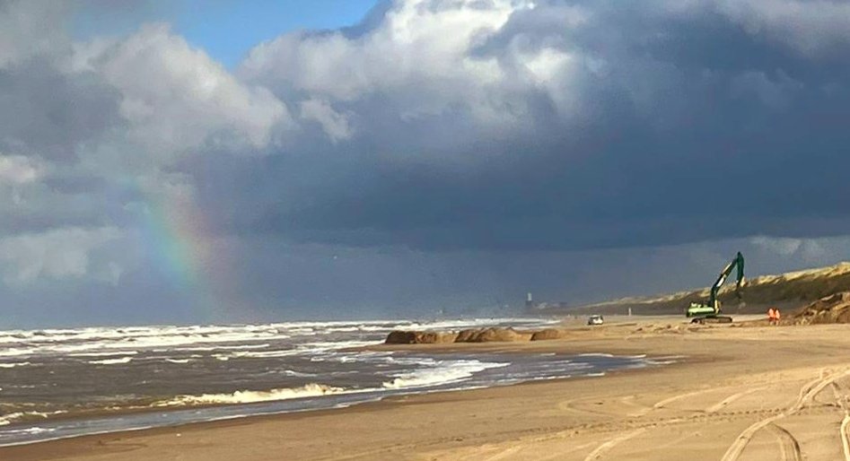 De graafmachine is bezig met het plaatsen van de bommen en zand erop te leggen