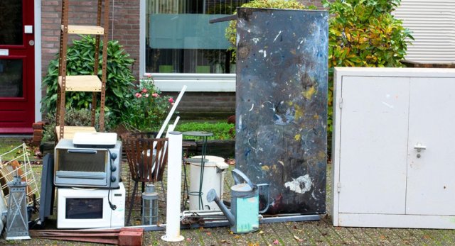 Verzameling van grofvuil op straat, oude kast, magnetron, kastjes, wasrek
