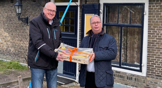 Burgemeester Han Weber reikt namens Mieke den Boer de prijs voor een jaar gratis fruit uit aan de Voedselbank