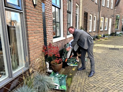 Wethouder Slingerland helpt mee tijdens het tegelwippen