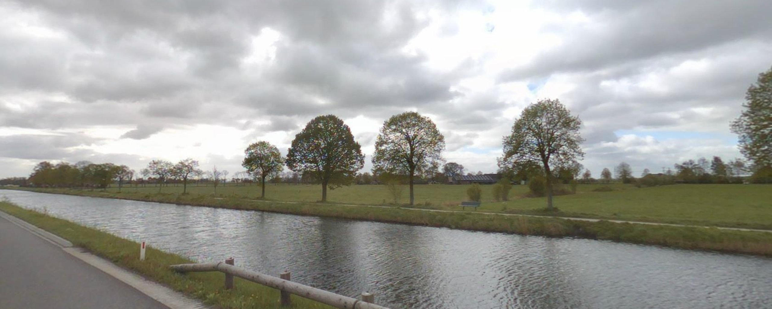 Weg langs de Dedemsvaart met weiland op het achtergrond
